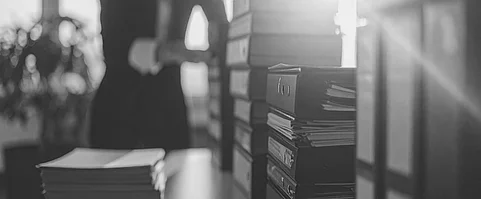 Mitarbeiter organisiert Dokumente am Büroschrank