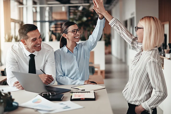 Erfolgreiche Teamarbeit: Frauen beim High Five im Meeting