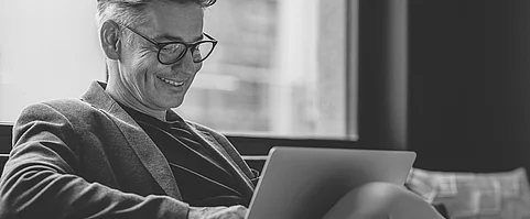 Mann arbeitet mobil in Büro-Empfangsbereich